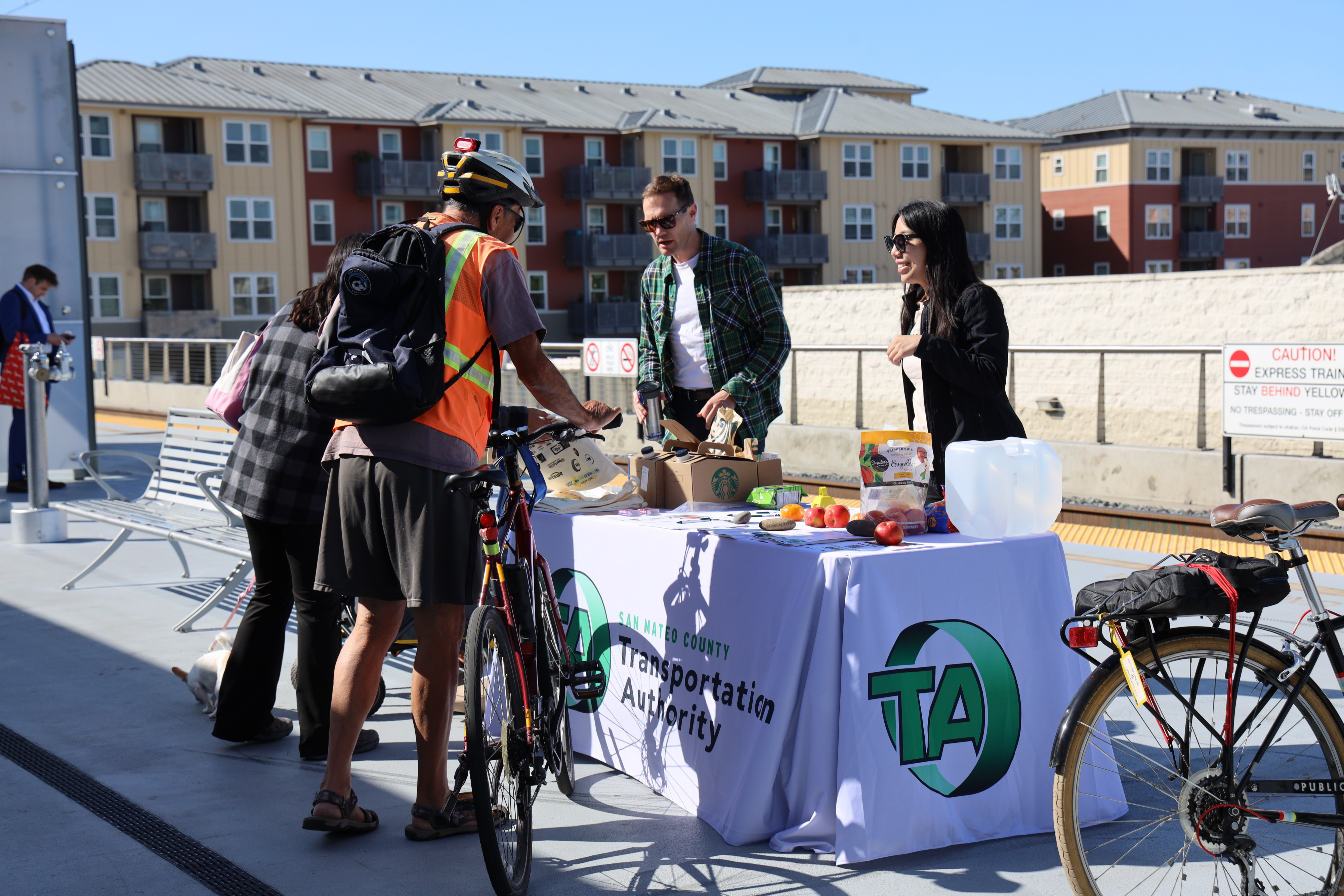 TA staff at table interacting with passersby