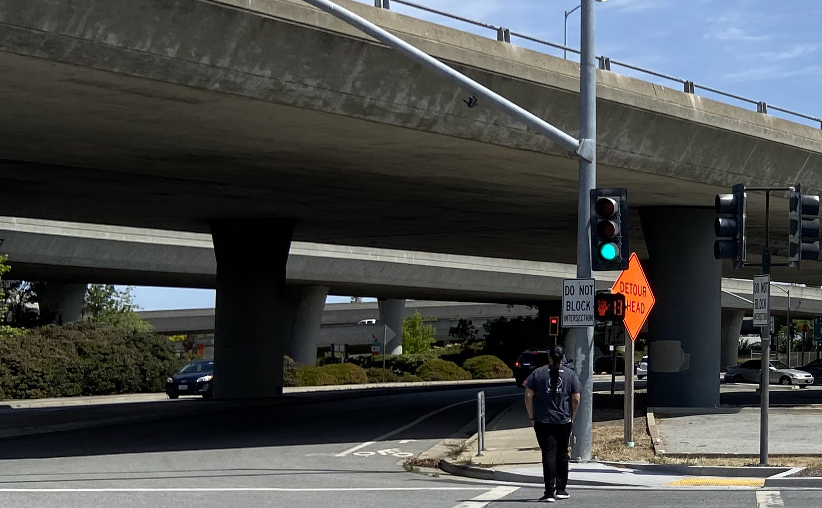 Image of person walking in a crosswalk next to the Caltrans Park and Ride lot
