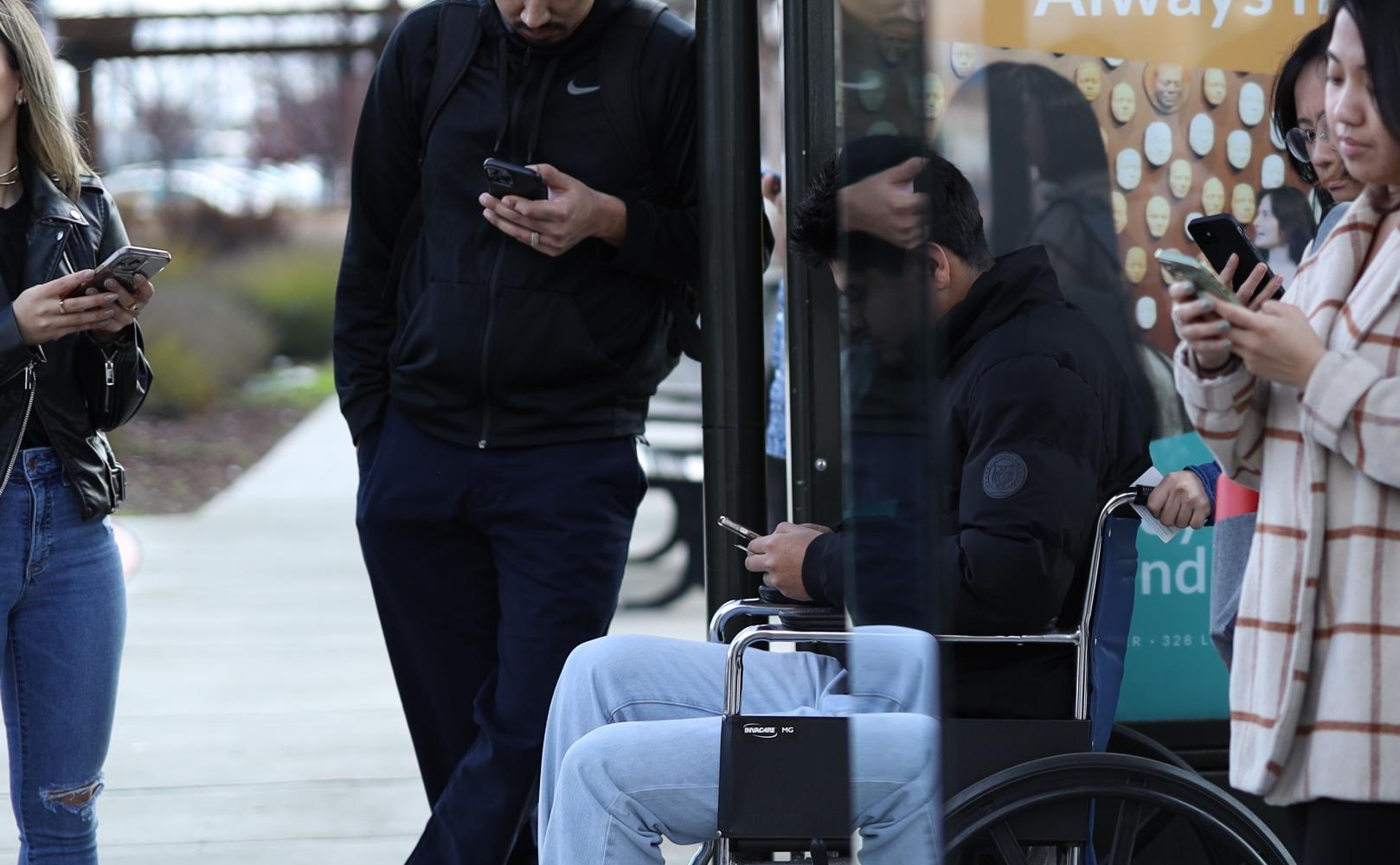 Crowd waits for bus at SamTrans bus stop