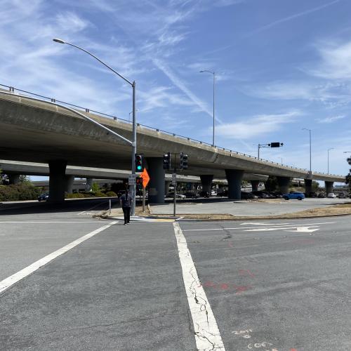 Image of person walking in a crosswalk next to the Caltrans Park and Ride lot