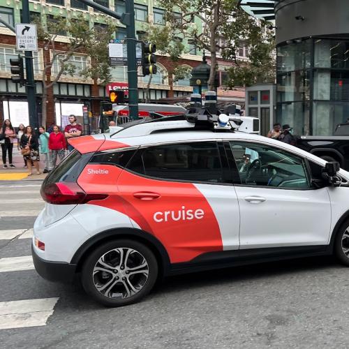 An automated taxi turns a corner in downtown San Francisco