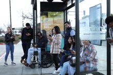 Crowd waits for bus at SamTrans bus stop